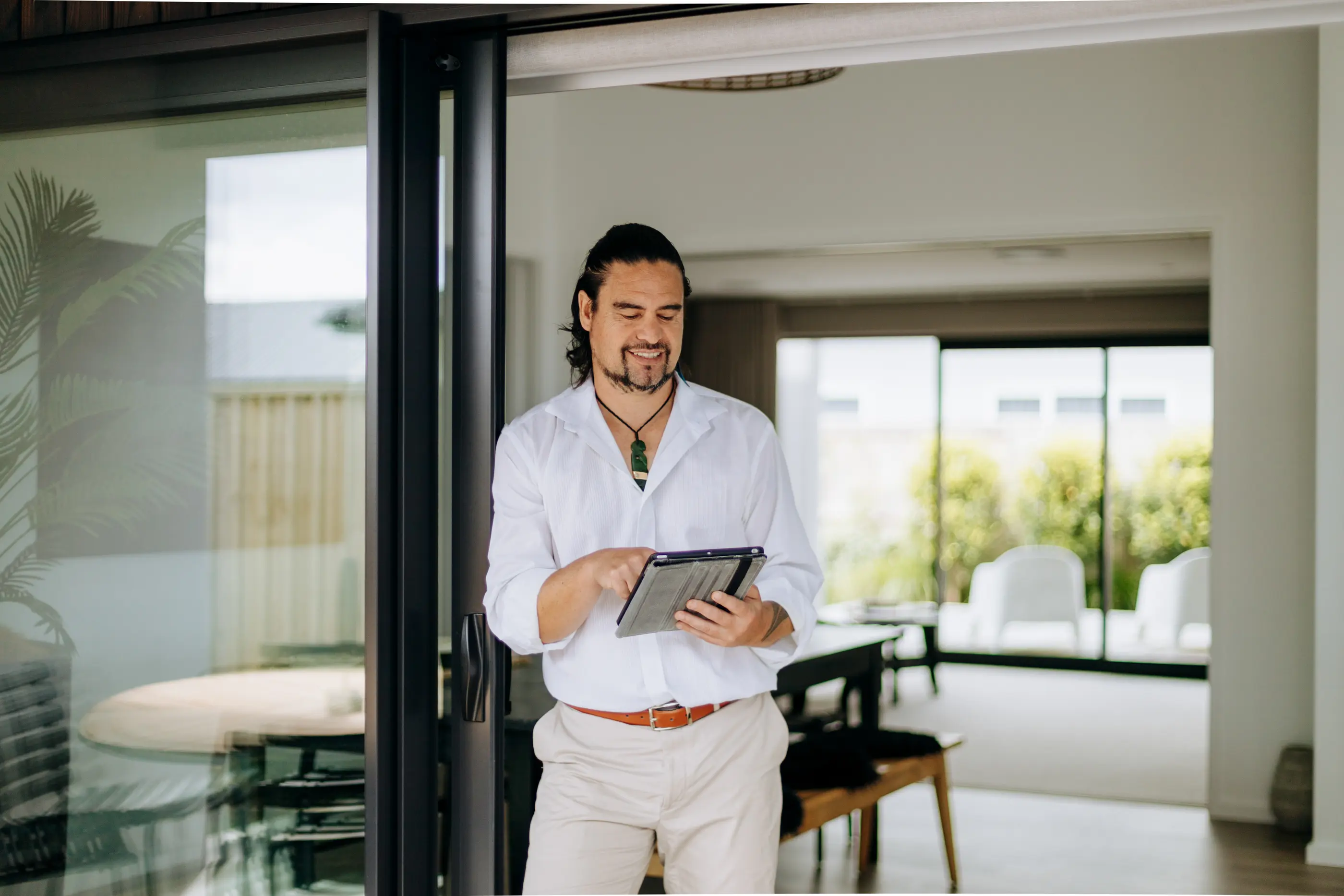Man with tablet smiling indoors