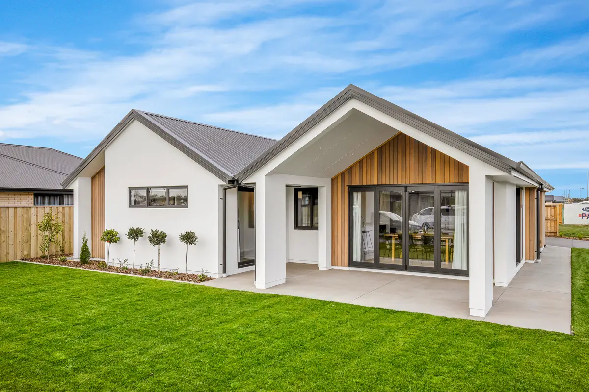 Rear exterior of a Classic Builders home with timber accents, covered patio and green lawn