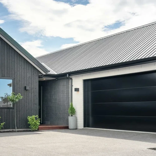 Modern single-story home with a black wooden exterior and garage door | Classic Builders