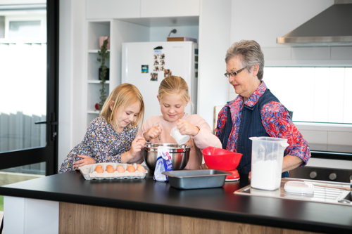 Children learning to bake with their grandmother.
